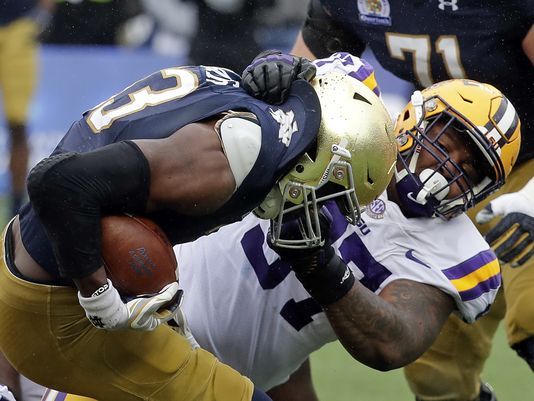 LSU defensive end Frank Herron, right, tackles Notre Dame running back Josh Adams during the first half of the Citrus Bowl NCAA college football game, Monday, Jan. 1, 2018, in Orlando, Fla. (AP Photo/John Raoux)