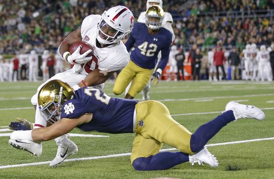 Stanford running back Bryce Love is tackled by Notre Dame defender Drue Tranquill during the first half.
