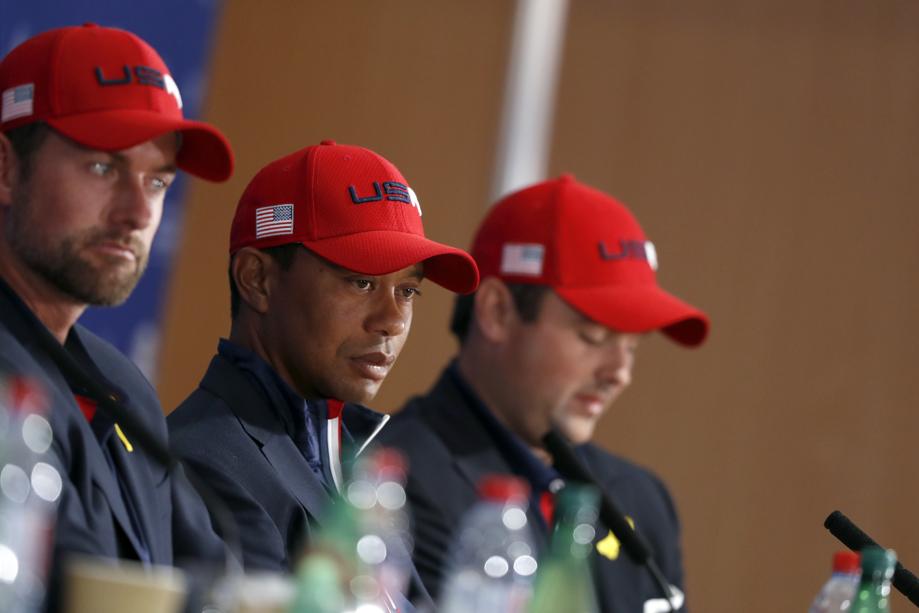 US players Webb Simpson, left, Tiger Woods and Patrick Reed, right, attend the press conference of the losing team after Europe won the 2018 Ryder Cup golf tournament at Le Golf National in Saint Quentin-en-Yvelines, outside Paris, France, Sunday, Sept. 30, 2018. (AP Photo/Alastair Grant)