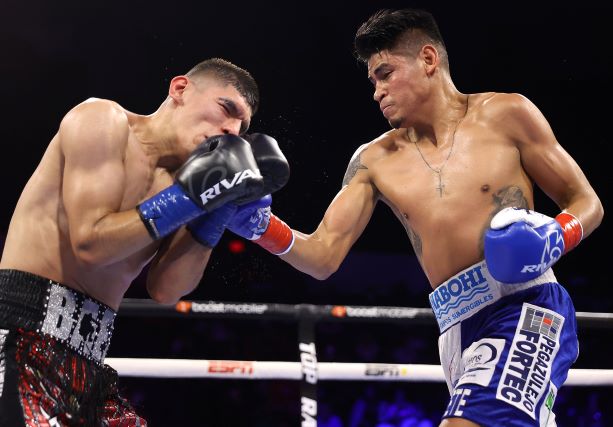 Emanuel Navarrete punches Eduardo Baez. Photo Credit: Mikey Williams / Top Rank via Getty Images