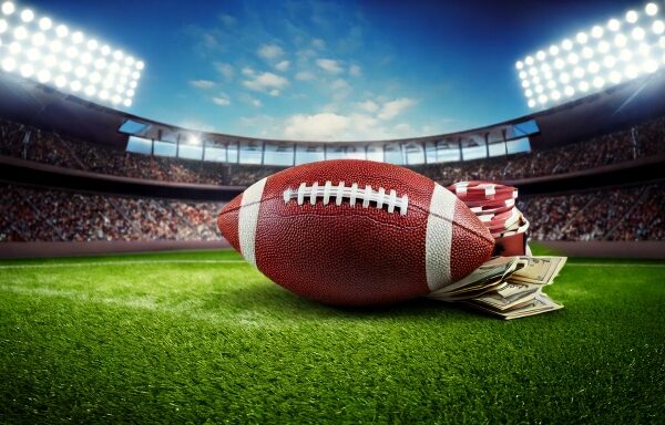 A football laying in a stadium with money laying beside it. Indicating gambling